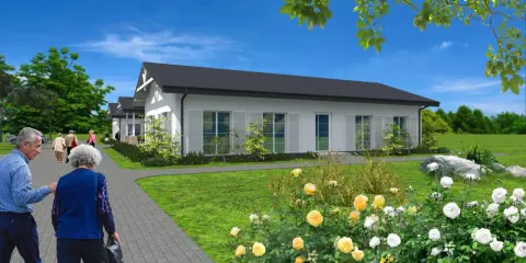 Urokliwy dom dla dwojga emerytów, z ogrodem pełnym róż. Spacerujący seniorzy cieszą się spokojem i zielenią.