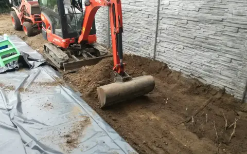 Koparka z walcem przygotowuje teren. To idealny sposób, czym wyrownac ziemie pod budowę lub ogród.