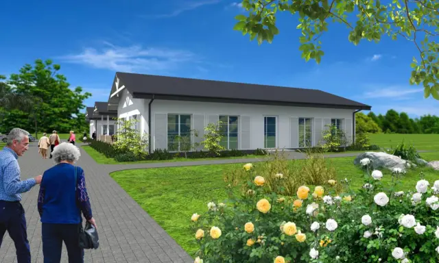 Urokliwy dom dla dwojga emerytów, z ogrodem pełnym róż. Spacerujący seniorzy cieszą się spokojem i zielenią.