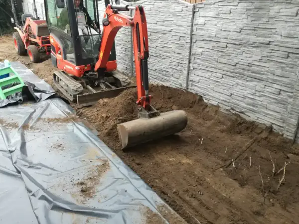 Koparka z walcem przygotowuje teren. To idealny sposób, czym wyrownac ziemie pod budowę lub ogród.